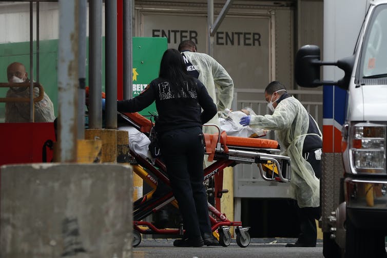 Des soignants transportent un patient sur un brancard, dans un hôpital de New York.