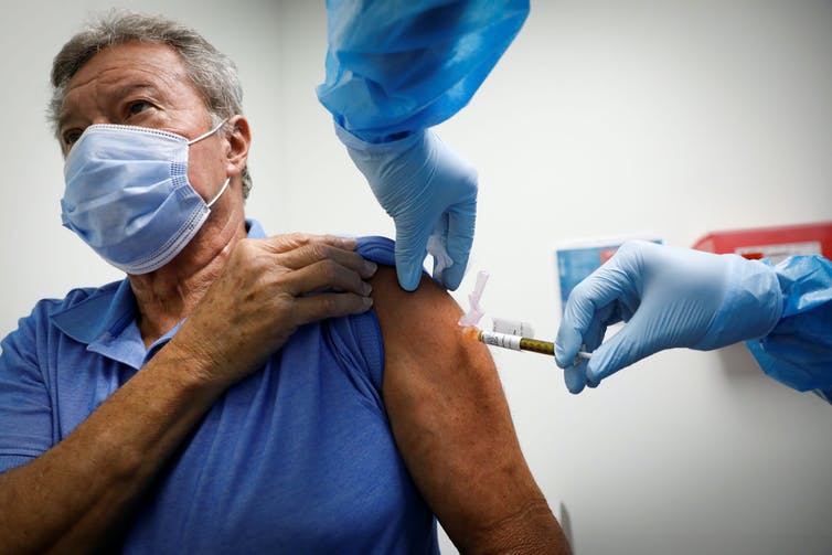 An older man receiving a Covid-19 vaccine